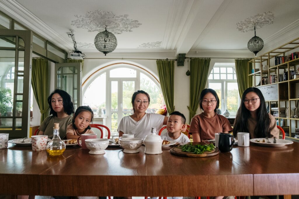 Three generations of a family gathered around the dinner table at home